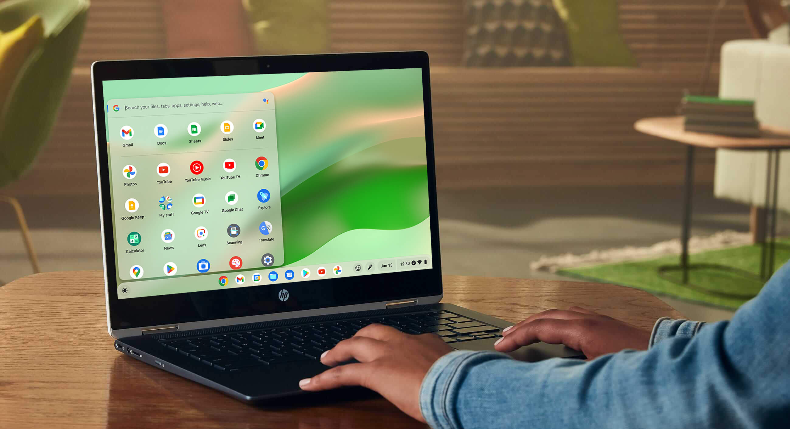 A woman in a coffee shop uses her Chromebook touchscreen to colour correct some landscape pictures from a mountain trip.